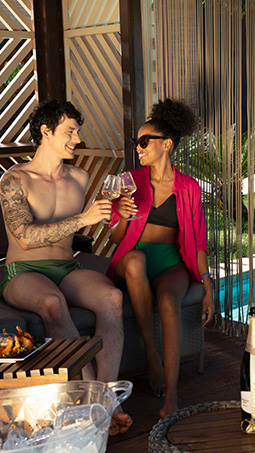 Casal brindando com bebidas ao lado da piscina no Hot Beach Resort Olímpia - Blog - Hot Beach Parques & Resorts | 