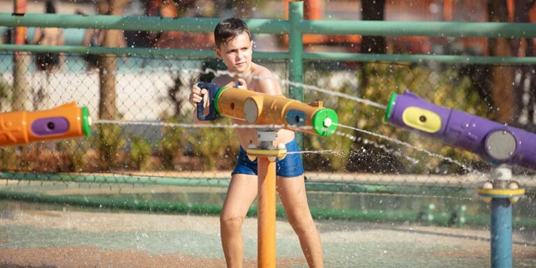criança brincando no paque aquatico com um disparador de agua
